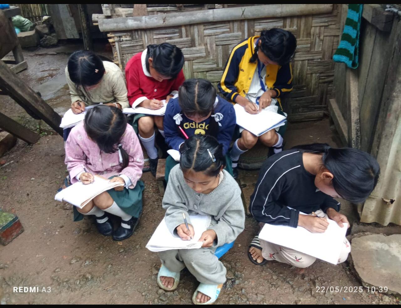 Learners in Manipur writing in notebooks during a community learning activity