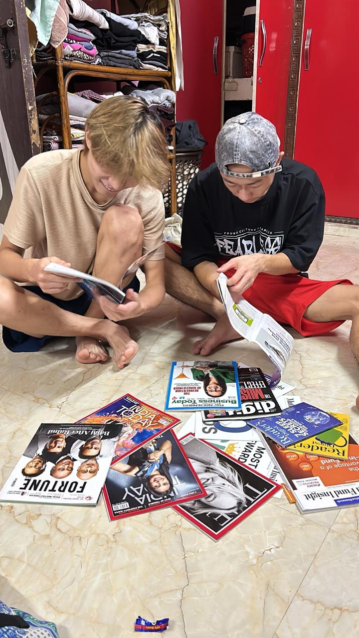 Learners reviewing magazines and printed media indoors